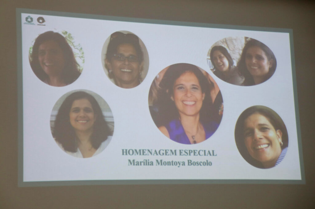 Slide projetado com o título "Homenagem Especial Marília Montoya Boscolo", mostrando várias fotos da mesma mulher sorridente em diferentes momentos.