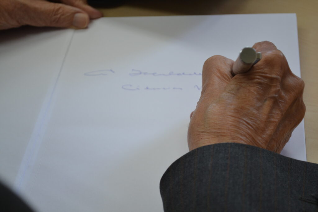 Detalhe da mão do médio cirurgião Antonio Prado Benedicto Fortuna. Ele autografa um livro de sua autoria para a Faculdade de Ciências Médicas da Unicamp. Na imagem é possível ler à Faculdade de Ciências Médicas...