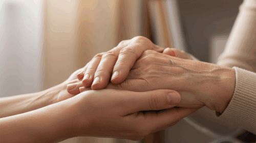 Close-up de mãos jovens segurando gentilmente as mãos enrugadas de uma pessoa idosa, simbolizando cuidado e apoio